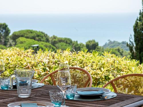 a wooden table with plates and glasses on it at Holiday Home Sabrina by Interhome in Castiglione della Pescaia