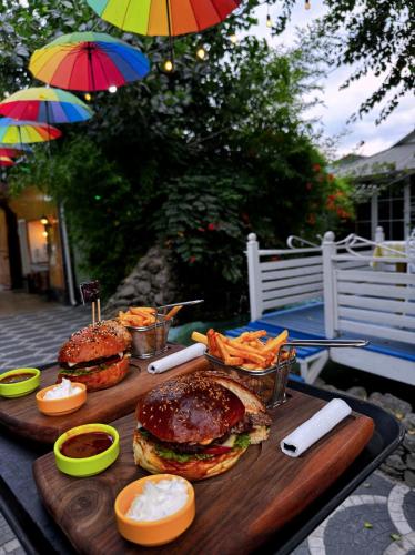 two hamburgers and fries on a table with umbrellas at Qafqaz Fountain Villa in Gabala