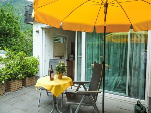 a table and chairs with an umbrella on a patio at Apartment Seestraße 60 by Interhome in Döbriach