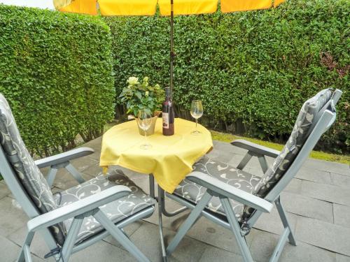 a table with two chairs and two glasses of wine at Apartment Seestraße 60 by Interhome in Döbriach