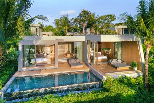 a house with a swimming pool in front of it at MASON, a member of Design Hotels in Na Jomtien