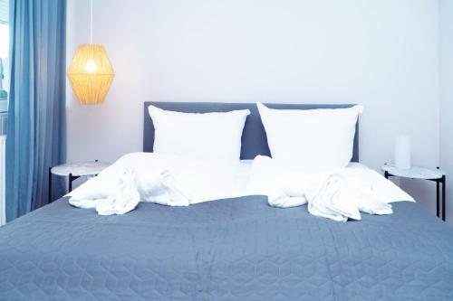 a bed with white sheets and pillows at Strandkoje - Strandmuschel in Neustadt in Holstein