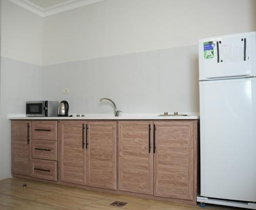 a kitchen with a sink and a refrigerator at Abu Alsoud Hotel in Amman