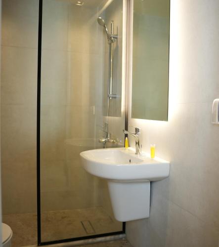 a bathroom with a white sink and a shower at Abu Alsoud Hotel in Amman