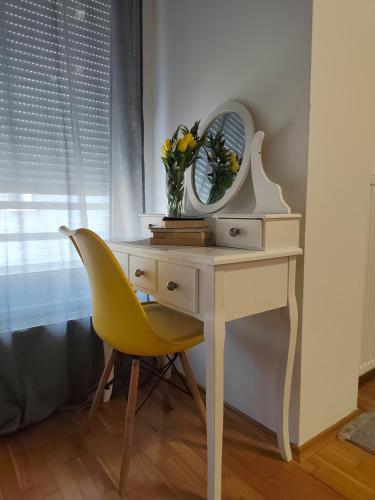 a desk with a mirror and a yellow chair at Kastel in Banja Luka