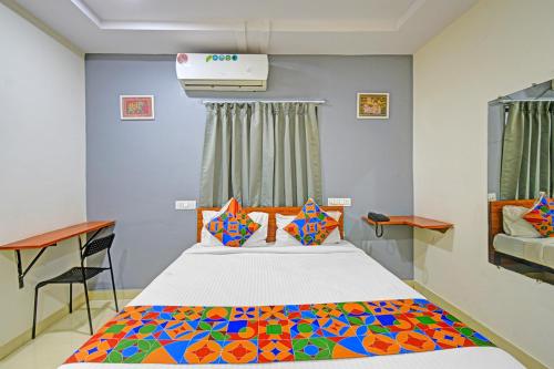 a bedroom with a bed with a colorful blanket at FabHotel AIG Broholic - 250M from AIG Hospital, Gachibowli in Hyderabad