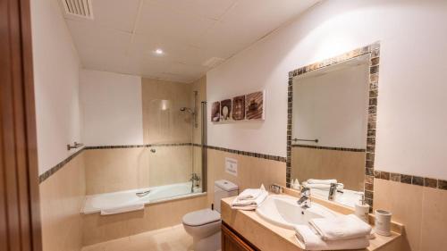 une salle de bain avec un lavabo, des toilettes et un miroir dans l'établissement Villa Grazalema 2 - Villa 39 Arcos de la Frontera by Ruralidays, à Arcos de la Frontera