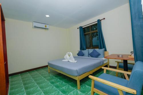 a bedroom with a bed and a table and a chair at Charung by The Sea in Haad Rin