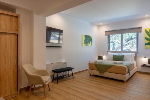 a bedroom with a bed and a chair and a window at AK-Green Villa near Athens Airport in Vravrona