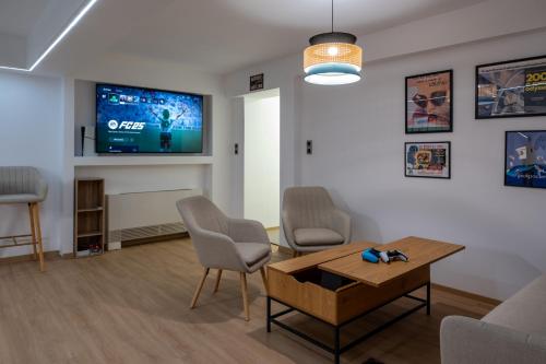 a living room with a table and chairs and a tv at AK-Green Villa near Athens Airport in Vravrona