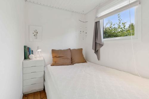 a white bedroom with a bed and a window at Holiday Home By The Sea With Space To Relax in Hørve