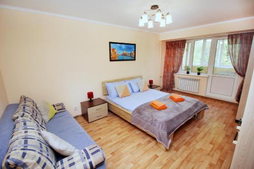 a bedroom with a bed and a couch at Меркур возле Аэропорта in Almaty
