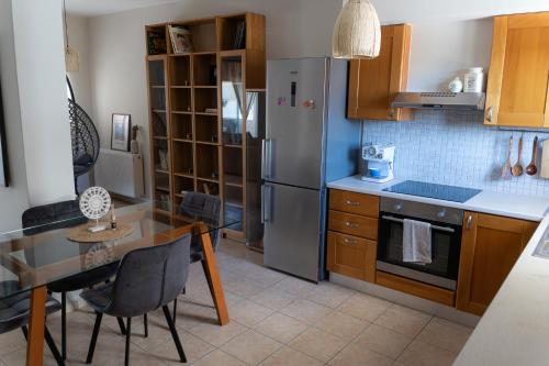 a kitchen with a stainless steel refrigerator and a table at Lovemade central apartment in Kos Town