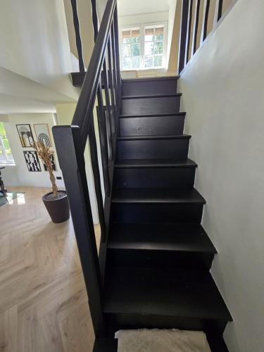 a black staircase in a house at Longère douce aux chants des oiseaux in Chéronvilliers