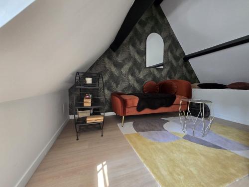a living room with a red couch and a table at Longère douce aux chants des oiseaux in Chéronvilliers