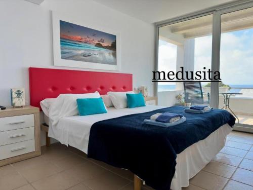 a bedroom with a large bed with a red headboard at Calatabarca B&B in Tabarca