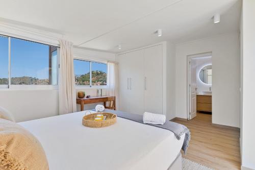 ein weißes Schlafzimmer mit einem großen Bett und einem Fenster in der Unterkunft Penthouse La Noria in Mijas Costa