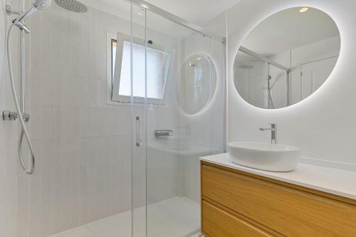 ein Badezimmer mit Dusche, Waschbecken und Spiegel in der Unterkunft Penthouse La Noria in Mijas Costa