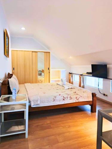 a bedroom with a large bed and a table at Sun Rise House in Jakarta