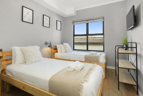 a bedroom with two beds and a window at Cape on Porterfield Unit 5 by Host Agents in Bloubergstrand