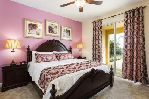 a bedroom with a large bed with pink walls at Villa EC036 in Orlando