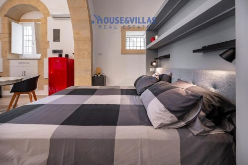 a bedroom with a bed with a black and white blanket at House&Villas - Kore in Noto