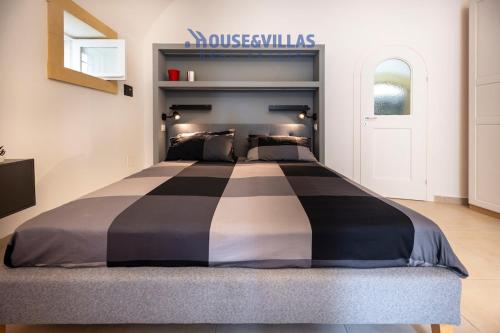 a large bed with a black and white comforter at House&Villas - Kore in Noto