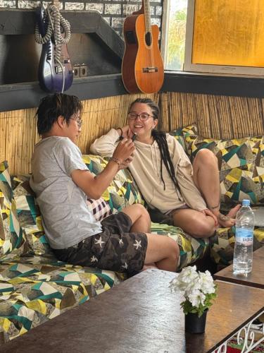 two men sitting on a couch with a guitar at Essaouira trip hostel in Essaouira