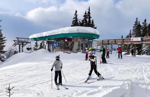 two people on skis in the snow near a ski lift at Ski, bike, hike & chill! in Sankt Kathrein am Hauenstein
