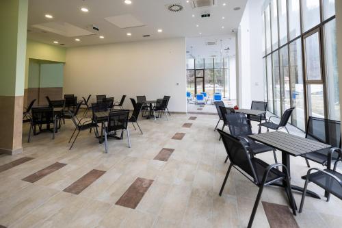 a dining room with tables and chairs and windows at Planinka in Kursumlijska Banja
