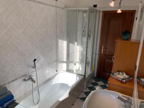 a bathroom with a tub and a shower and a sink at La Vigna in Montignoso