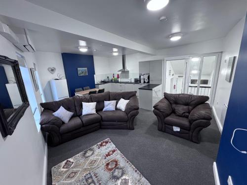 a living room with two couches and a kitchen at 11 Comberton hill in Kidderminster