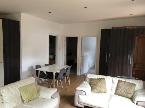 a living room with a white couch and a table at Cosy South Gloucestershire Cabin Retreat in Yate