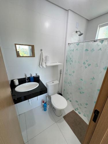 a bathroom with a toilet and a sink and a shower at Apartamento Beira-Rio in Barreirinhas