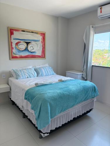 a bedroom with a bed with a painting on the wall at Apartamento Beira-Rio in Barreirinhas