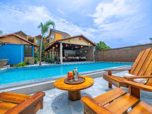 a patio with two wooden benches next to a swimming pool at Chilling Homestay - Hotel in Vũ Lâm