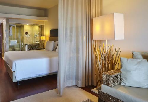a bedroom with a bed and a couch in a room at Crowne Plaza Vilamoura - Algarve by IHG in Vilamoura