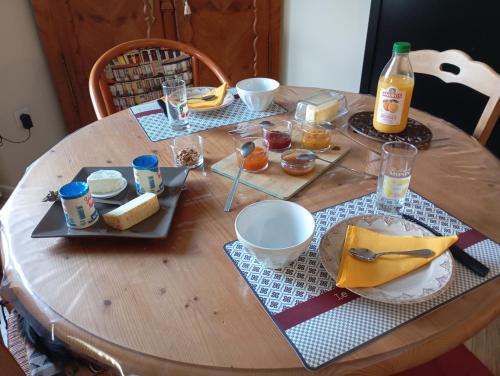 a wooden table with food and drinks on it at La Cousinière in Clohars-Carnoët