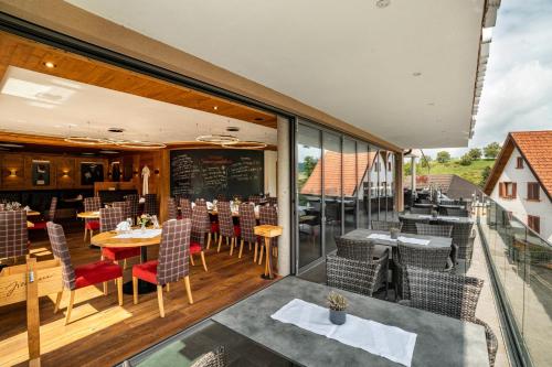 a restaurant with a balcony with tables and chairs at Wein- und Klimahotel Bergfriedel in Bühlertal