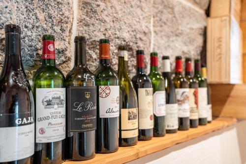 a row of wine bottles on a wooden shelf at Wein- und Klimahotel Bergfriedel in Bühlertal