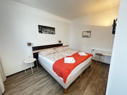 a bedroom with a bed with a red blanket at Studio65 Vienna in Größing
