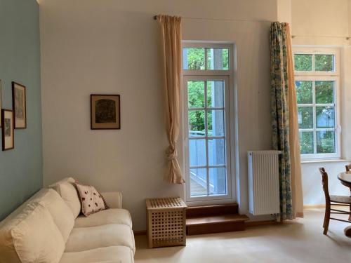 a living room with a couch and a window at Auberge Tabarz Breitenberg in Tabarz