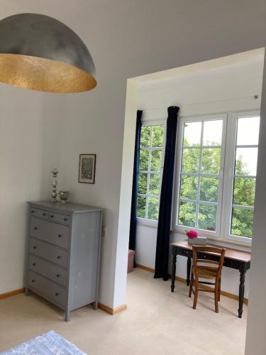 a bedroom with a desk and a table and windows at Auberge Tabarz Breitenberg in Tabarz
