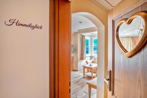 a hallway with a mirror and a living room at Wein- und Klimahotel Bergfriedel in Bühlertal