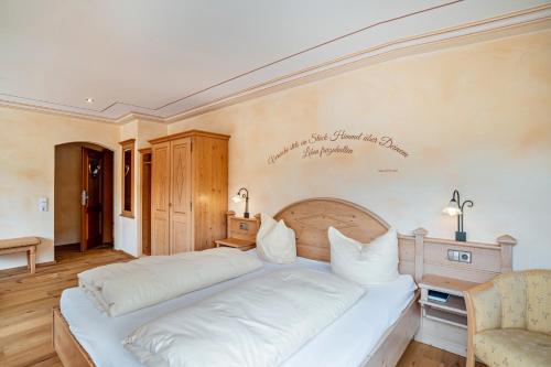 a bedroom with a large bed with white sheets at Wein- und Klimahotel Bergfriedel in Bühlertal