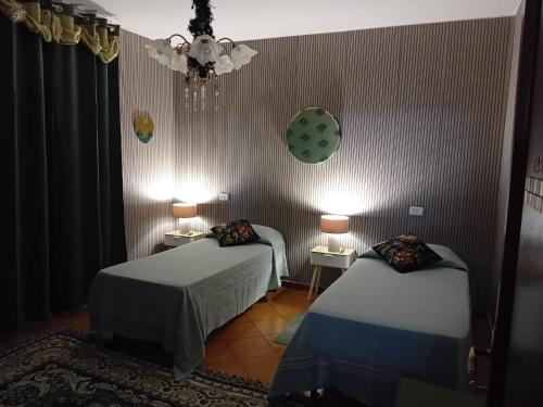 a room with two beds and a clock on the wall at La Sosta in Lunigiana in Monti di Licciana Nardi