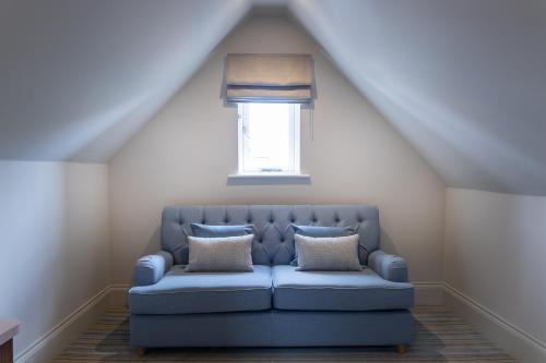 a blue couch in a room with a window at The Ship Hotel in Southend-on-Sea