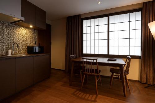 a kitchen with a table and chairs and a window at Minn Kanazawa in Kanazawa