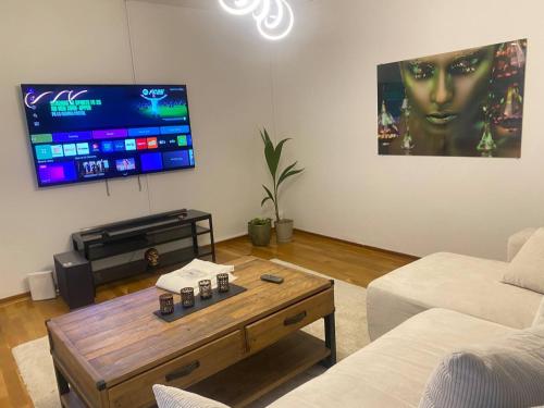 a living room with a tv and a coffee table at Liseberg-Near Apt City Centre WOW Fest in Gothenburg