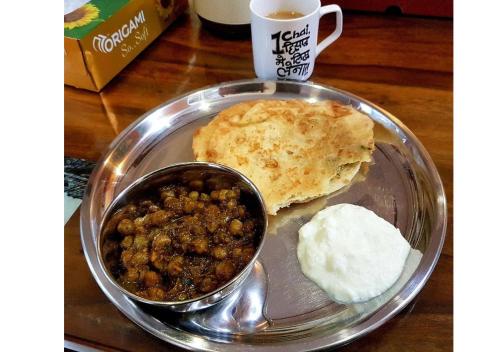 um prato de comida com carne e pão e uma colher em Diya Bed and Breakfast em Nova Deli